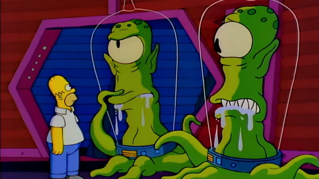 Homer, minuscule, fait face à deux extraterrestres verts à œil unique et tentacules, baveux sous leurs cloches transparentes